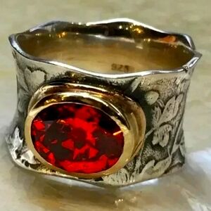 Imitation red moonstone set in a gold toned base on a silver toned band. Size 8.